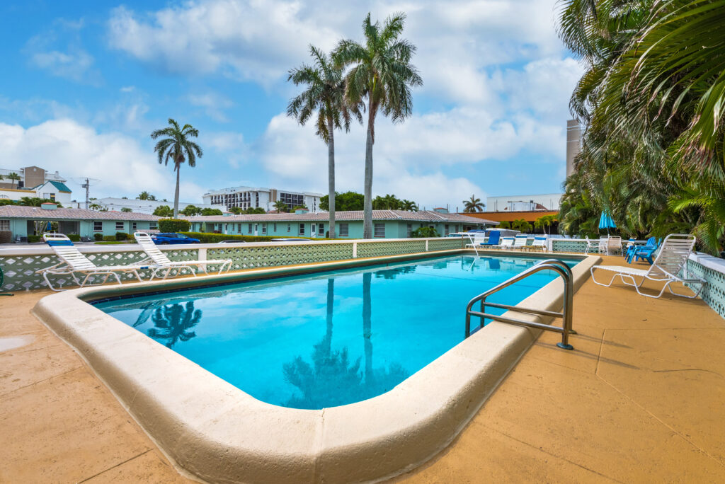 Outdoor pool with palm trees at The Grove Beach Condos Delray Beach FL